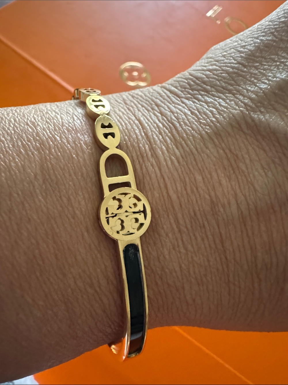 Burch Gold Tone Bangle with Black Inlay and Logo Medallion